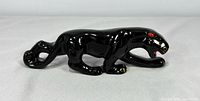 Side view of glossy black ceramic panther figurine