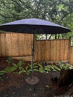 Umbrella open showing canopy color and size, base visible