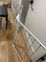 wide white metal safety gate showing panels and hinges