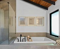 Three framed prints above bathtub showing full set