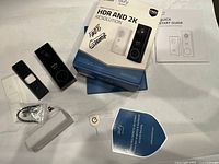 All components laid out: doorbell, chime, faceplates, bracket, wedge, hardware, sticker, manual, box