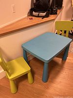 Blue Ikea Mammut table with two lime green chairs