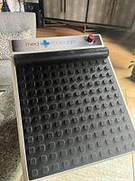 Foot massager unit showing textured pad and control knob