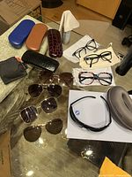 Overall view of all eyewear, cases, cloths and accessories on table
