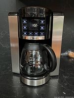 Front view showing stainless steel sides, digital display, carafe in place