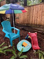 Full lot view showing chair, umbrella, slide, pool ring