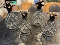 Four glass pineapple ornaments on table