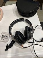 Headphones folded with attached cable, carry case, Kolbe ear plugs visible