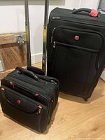 Large and small Swiss Gear black wheeled suitcases side by side