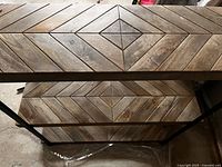 Close view of two wood shelves showing chevron pattern