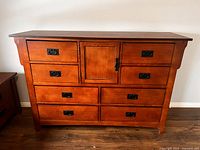 Full view of dresser showing nine drawers, center cabinet, hardware, overall style