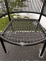 Close view of chair seat showing woven vinyl lattice and torn strands