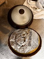 Both ceiling fixtures, one assembled showing frosted glass dome and bronze rim, second upside-down showing wiring