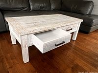 Front angle showing whitewashed coffee table, one drawer open