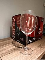Single loose Gastro wine glass in front of boxed set