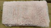 Folded pink faux fur rug on cardboard