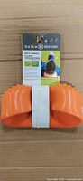 Front view of orange Gaiam Restore neck cradle with retail card