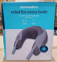 Retail box front displaying HoMedics vibration neck massager with heat