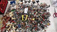 Wide view of entire lot spread on table showing large quantity of figures and accessories