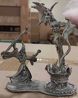 Front view of pewter figurine showing wizard, demon and cauldron