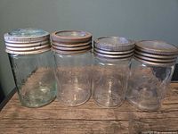 Front view of four mason jars showing tint, embossing and lids
