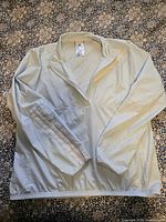 Front view of Adidas light blue windbreaker showing quarter-zip, overall condition, elastic hem