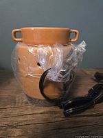 Ceramic Maize warmer wrapped in plastic with cord visible