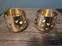 Two brass holders front view showing heart cutouts