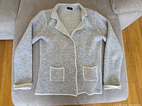 Full view of cardigan blazer laid flat showing overall style and trim