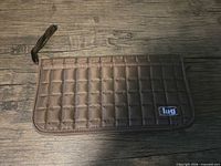 Front view of brown Lug quilted wallet case showing logo patch