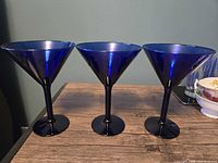Front view of three cobalt blue martini glasses on tabletop