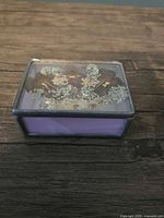 front view of closed lavender stained glass box showing pressed flowers under glass lid