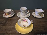 Front view of four teacup and saucer sets