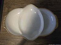 Top view of divided milk glass dish showing three compartments and gold beaded edge