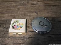 Closed square and round compact mirrors, lids visible