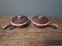 two lidded handled bowls front view