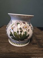 Front view showing daisy floral motif and base trim