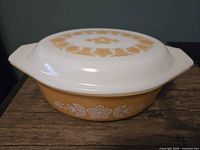 Side view of casserole showing gold exterior and white floral design
