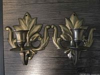 Front view of both brass leaf wall sconces showing design and condition