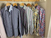 Five shirts on hangers showing patterns and colours