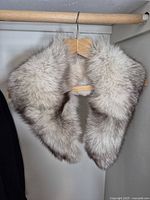 Front view of wolf fur collar hanging on hanger showing fur texture and shape