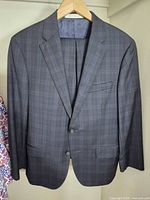 Front of navy plaid Samuelsohn suit jacket on hanger