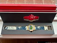 Watch laid flat inside branded presentation box