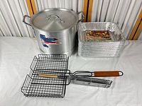 Full lot showing stock pot with lid, stack of foil pans, grill basket