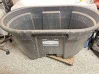 Full view of Rubbermaid 100-gallon oval stock tank on wooden dolly