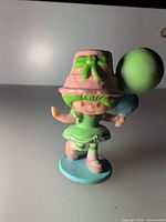 Front view of figurine showing outfit and balloons