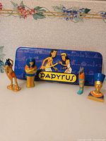 Full lot showing five figurines and Papyrus tin