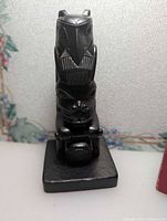 Front view of black raven totem pole figurine on base