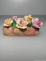 Front view showing multicoloured bone china roses and rectangular base