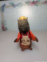 Front view of squirrel figure showing hat, jacket, apron and plastic hands/feet